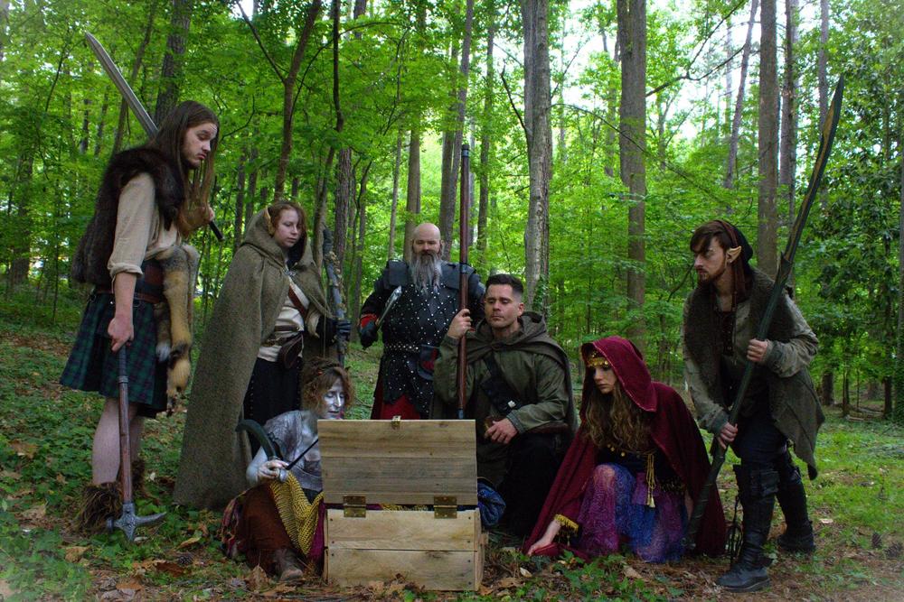 Adventurers around a chest in the forest